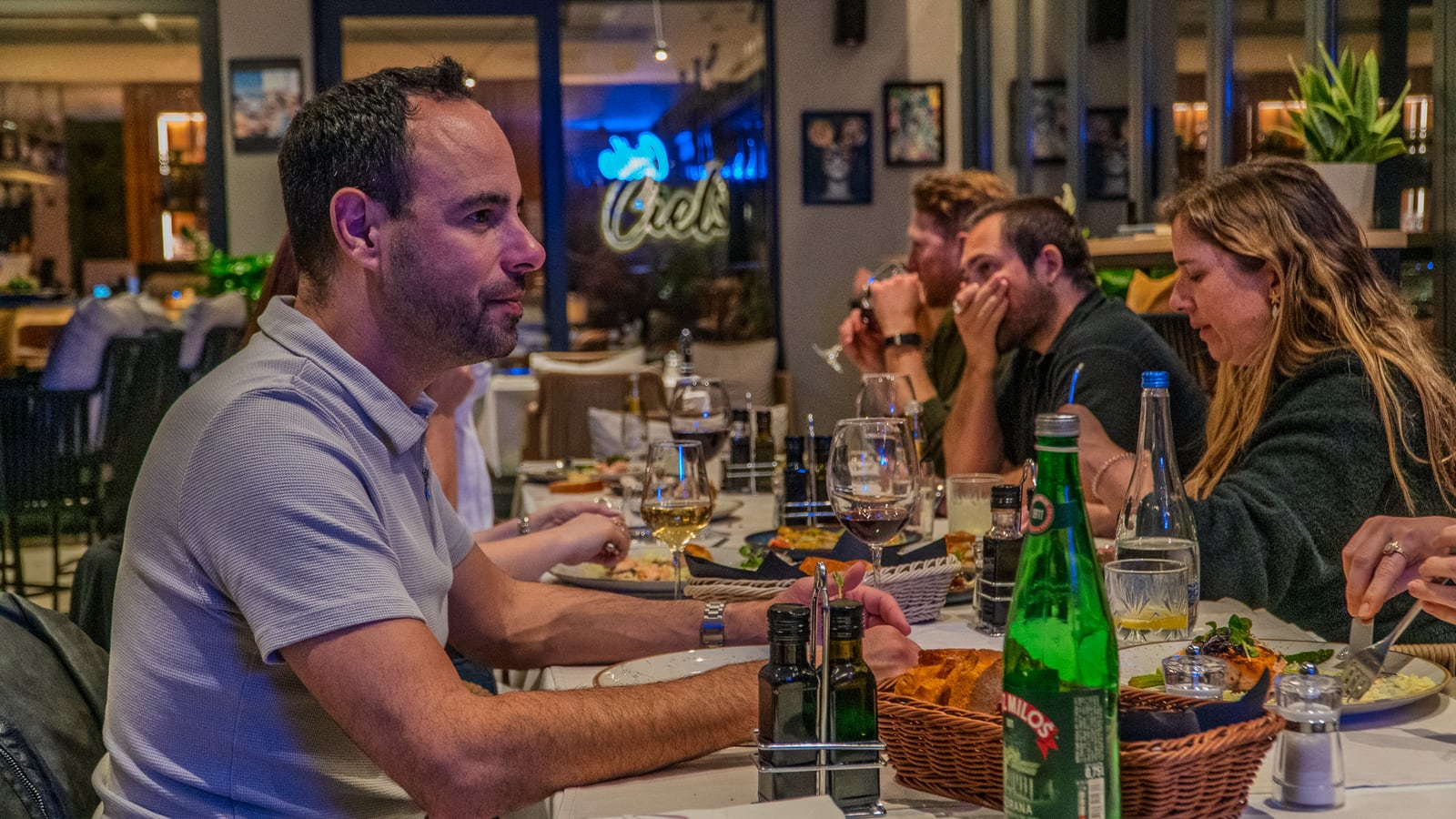 Nomio residents sharing dinner around a table at Cielo Rooftop