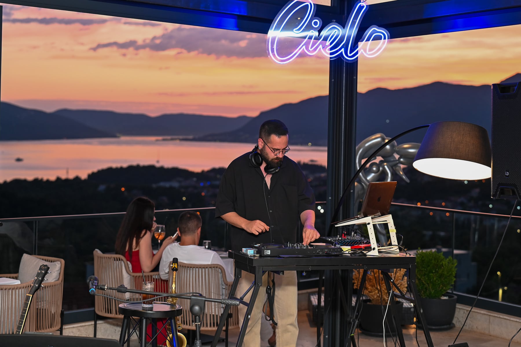 A DJ playing at Cielo Rooftop as the sun sets over the Bay of Kotor