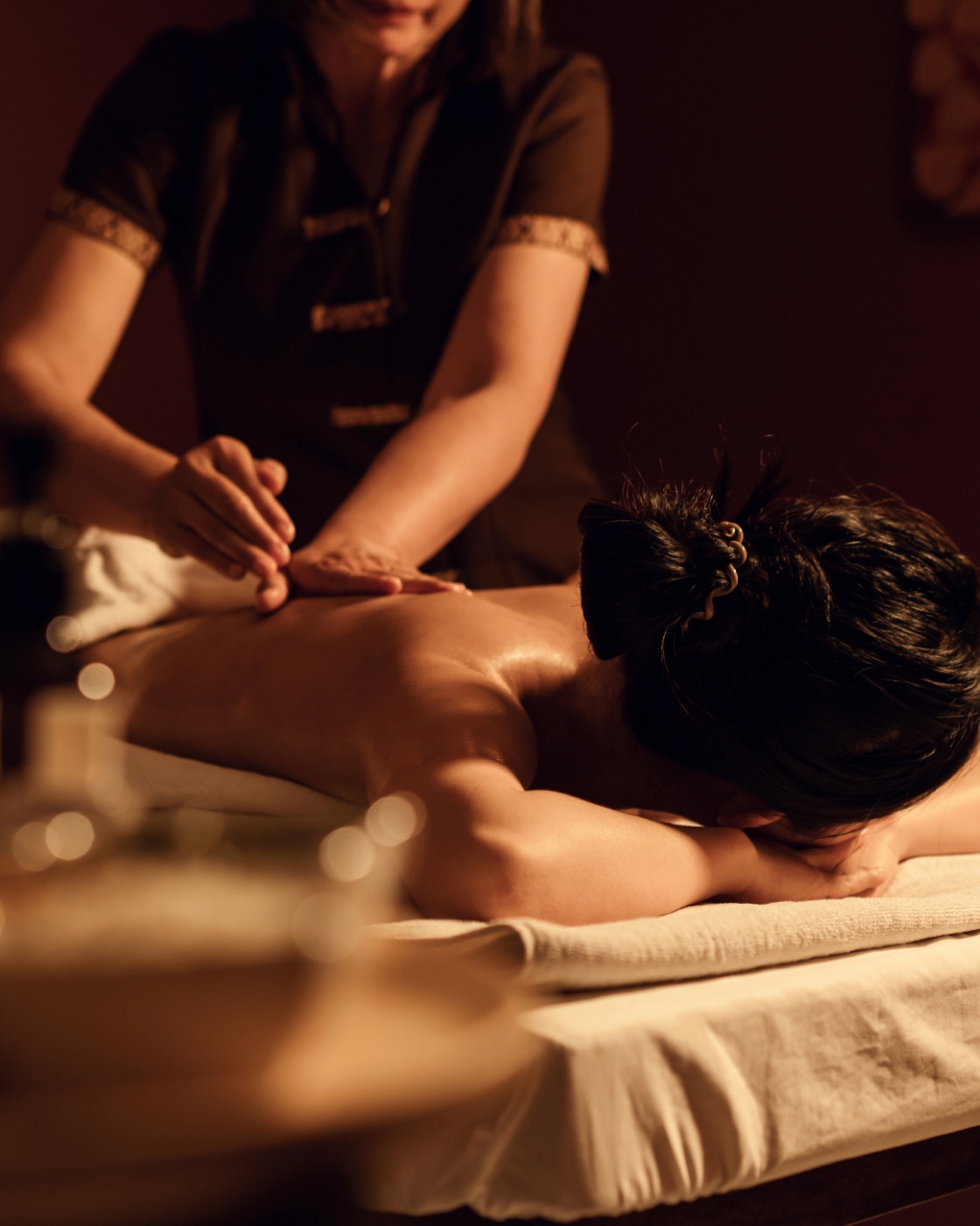A spa therapist providing a separately bookable massage treatment